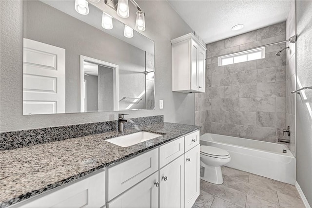 full bathroom featuring vanity, toilet, tiled shower / bath combo, and a textured ceiling