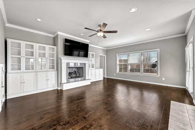 unfurnished living room with a premium fireplace, crown molding, hardwood / wood-style floors, and ceiling fan