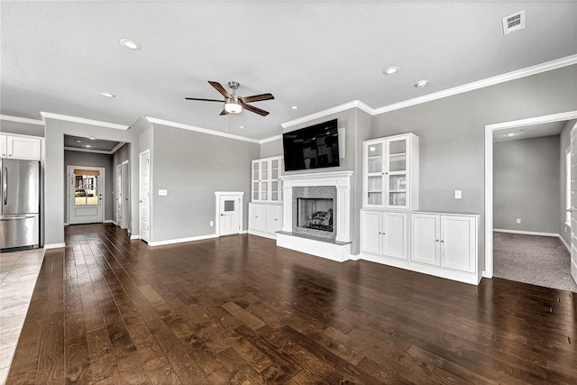 unfurnished living room with hardwood / wood-style flooring, a premium fireplace, ornamental molding, and ceiling fan