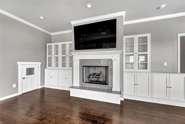 unfurnished living room with dark wood-type flooring, ornamental molding, and a fireplace