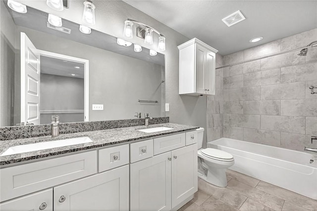 full bathroom featuring tiled shower / bath combo, vanity, and toilet