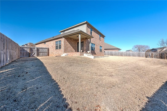 rear view of house featuring a lawn