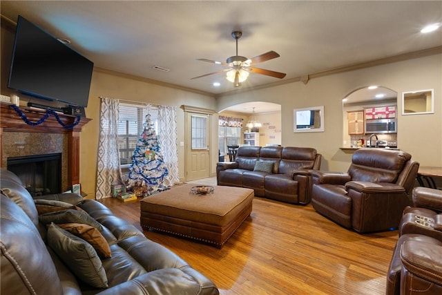 living room featuring sink, ornamental molding, light hardwood / wood-style floors, and ceiling fan