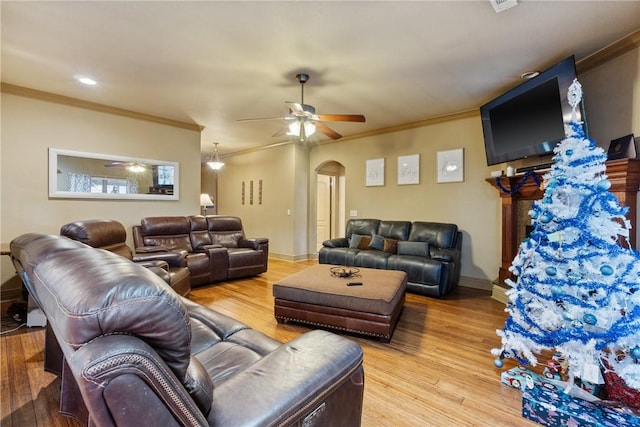 living room featuring crown molding, light hardwood / wood-style flooring, and ceiling fan