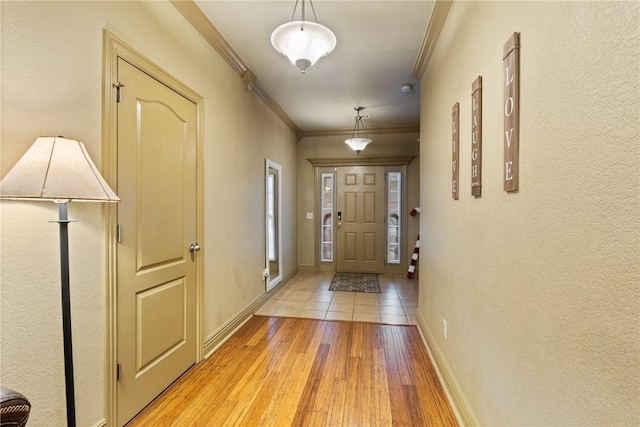 doorway to outside featuring crown molding and light hardwood / wood-style flooring