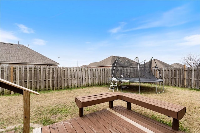 deck with a trampoline and a lawn