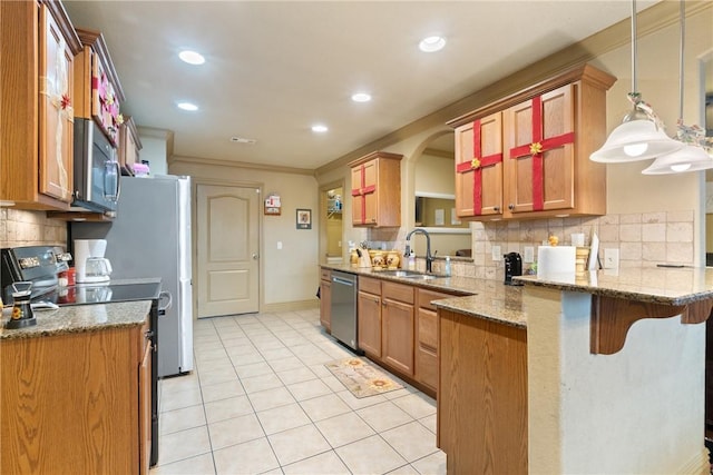 kitchen featuring sink, appliances with stainless steel finishes, hanging light fixtures, a kitchen bar, and kitchen peninsula