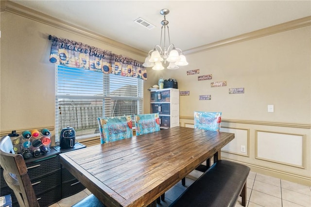 tiled dining area with crown molding and a notable chandelier