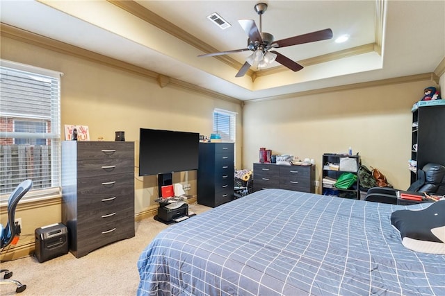 bedroom featuring crown molding, light colored carpet, a tray ceiling, and ceiling fan