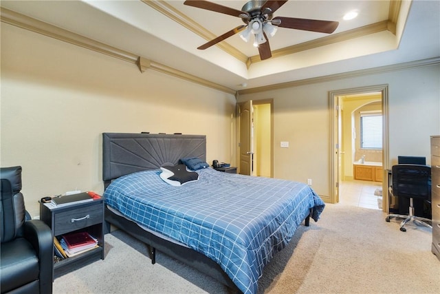 carpeted bedroom featuring crown molding, ensuite bath, and a tray ceiling