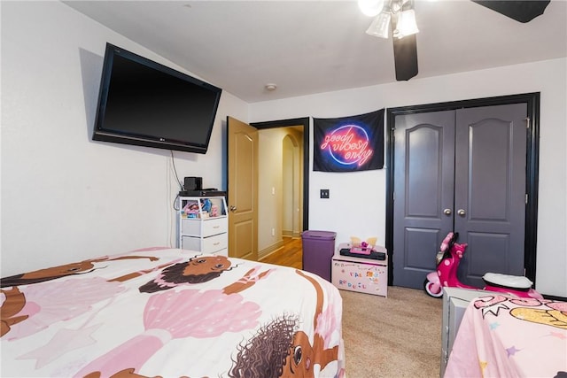 carpeted bedroom featuring a closet and ceiling fan