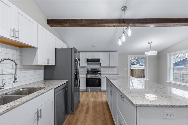 kitchen featuring sink, vaulted ceiling with beams, white cabinetry, hanging light fixtures, and appliances with stainless steel finishes