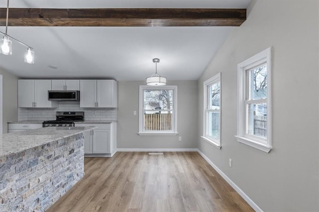 kitchen featuring appliances with stainless steel finishes, pendant lighting, beam ceiling, decorative backsplash, and white cabinets