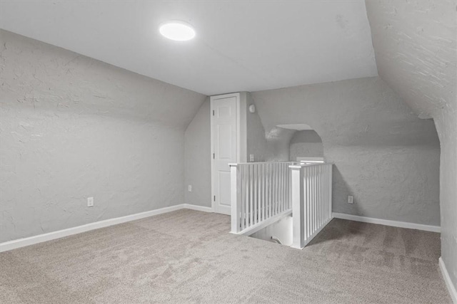 additional living space with carpet floors and vaulted ceiling