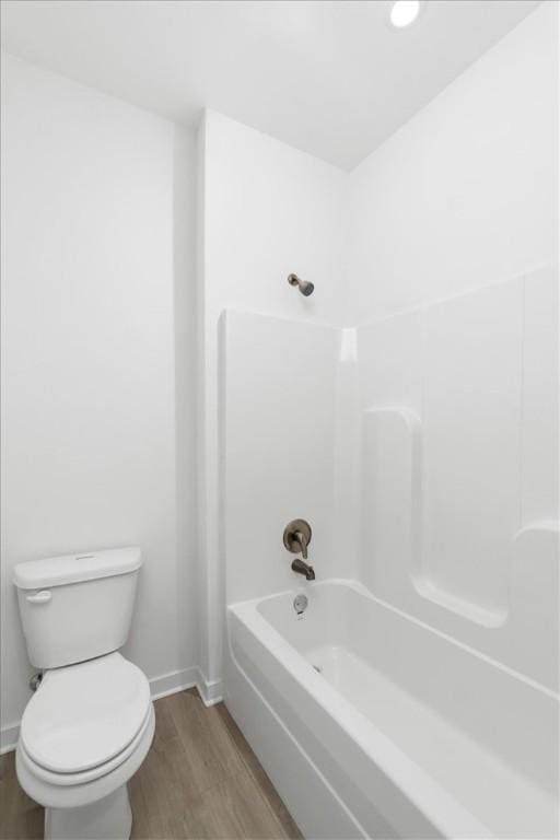 bathroom with bathing tub / shower combination, hardwood / wood-style floors, and toilet