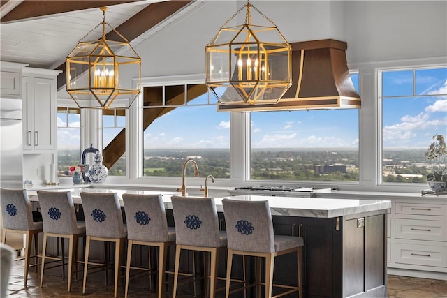 kitchen with white cabinetry, a notable chandelier, plenty of natural light, and a center island