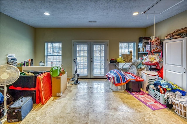 game room with french doors and a textured ceiling