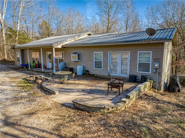 back of property with a fire pit, a patio, and french doors