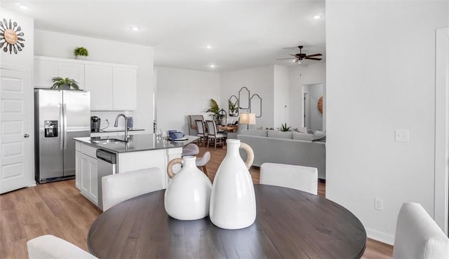 dining area featuring sink, light hardwood / wood-style floors, and ceiling fan