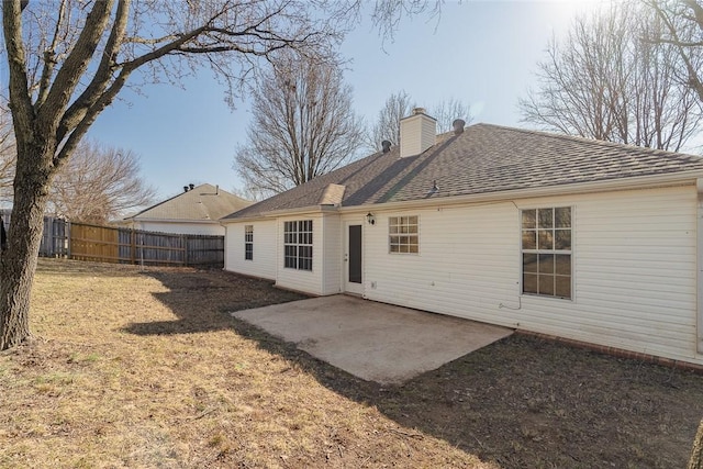 rear view of house featuring fence, a patio area, a chimney, and roof with shingles