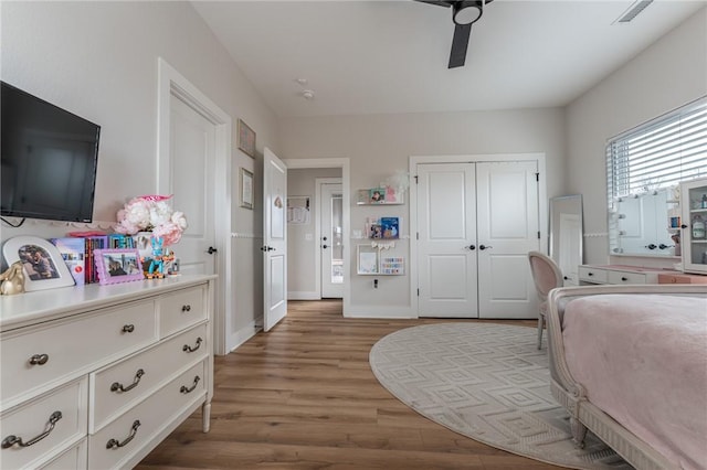 bedroom featuring ceiling fan, light hardwood / wood-style floors, and a closet