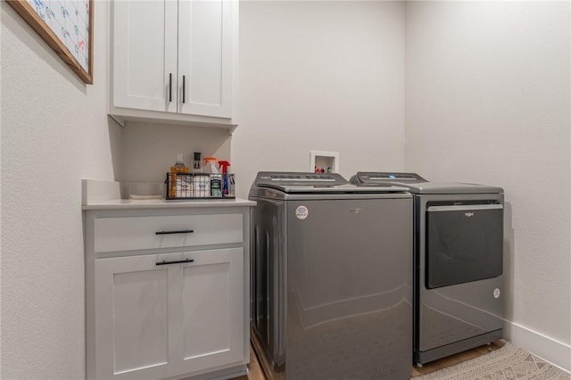 laundry area featuring cabinets and washing machine and clothes dryer