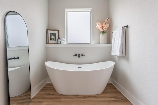 bathroom featuring hardwood / wood-style flooring and a washtub