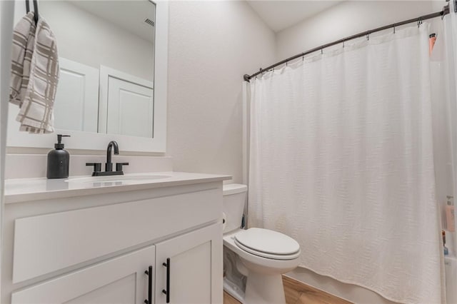 bathroom with vanity, wood-type flooring, and toilet