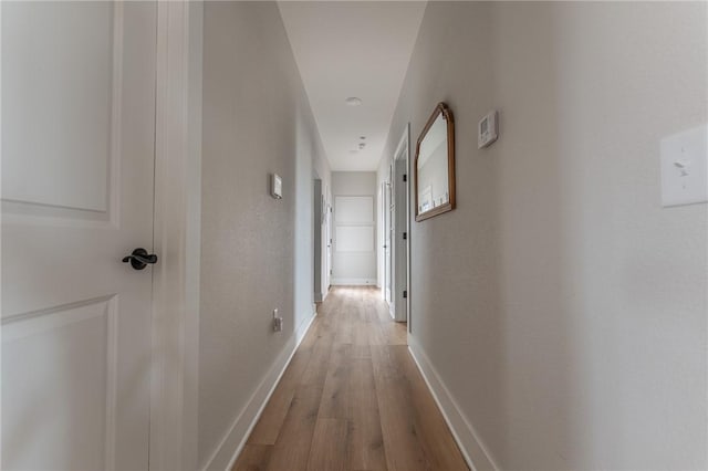 hallway with light hardwood / wood-style flooring