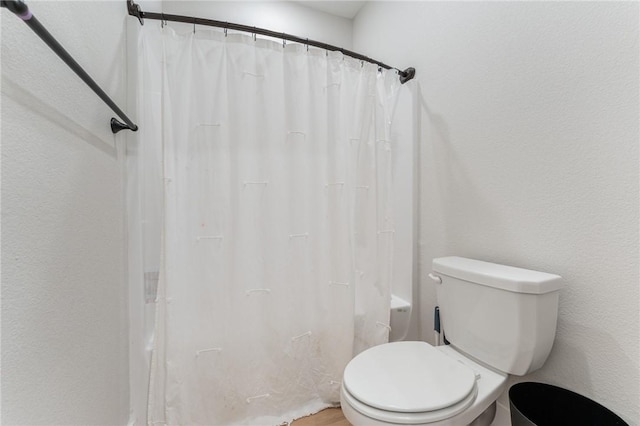 bathroom with shower / tub combo with curtain and toilet