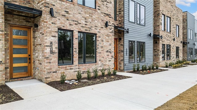 property entrance featuring brick siding