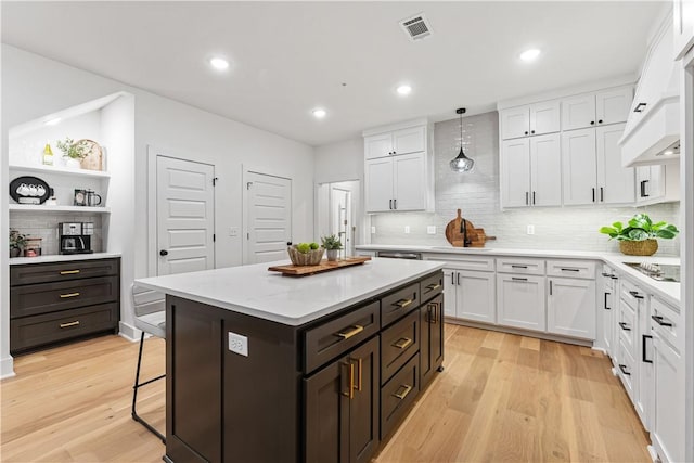4124 W Olive St, Rogers, AR 72756 - kitchen with light wood-style floors, decorative backsplash, white cabinetry, and visible vents