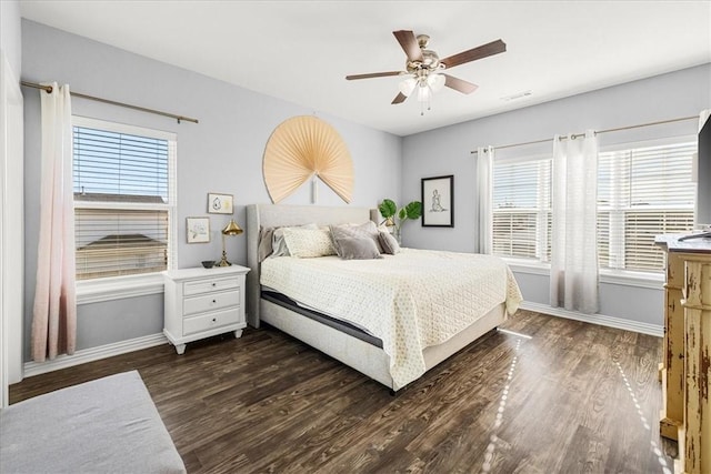 bedroom with dark hardwood / wood-style flooring, multiple windows, and ceiling fan