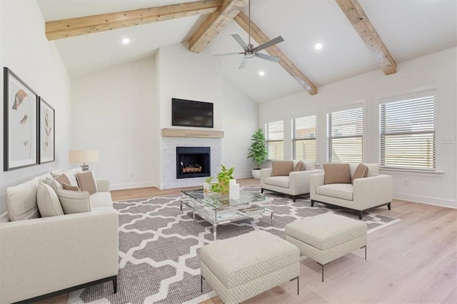 living room featuring plenty of natural light, beam ceiling, and light hardwood / wood-style floors