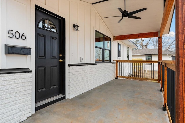 view of exterior entry with ceiling fan and a porch