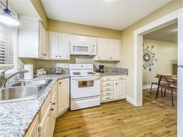 kitchen with white appliances, light hardwood / wood-style floors, sink, and white cabinets