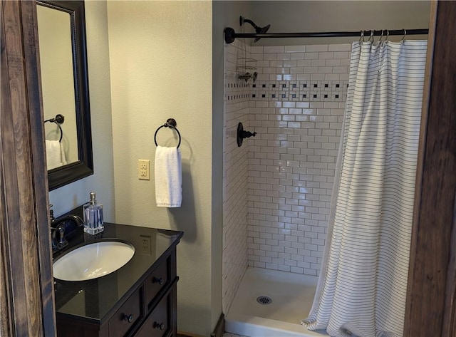 bathroom featuring walk in shower and vanity