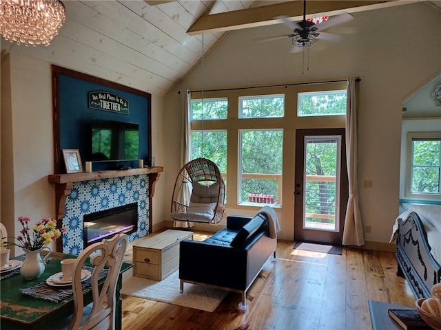 living room with beamed ceiling, ceiling fan, high vaulted ceiling, and light hardwood / wood-style flooring