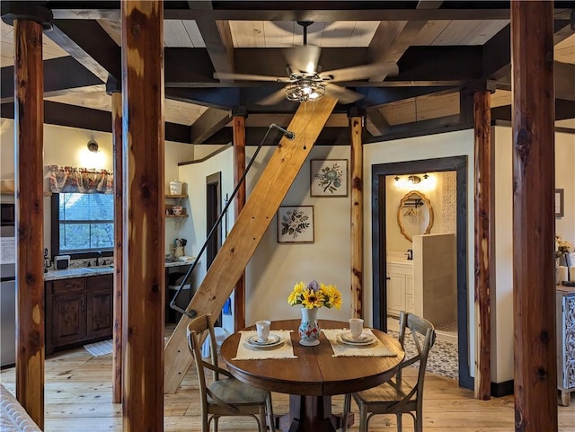 dining area with beam ceiling, ceiling fan, and light wood-type flooring