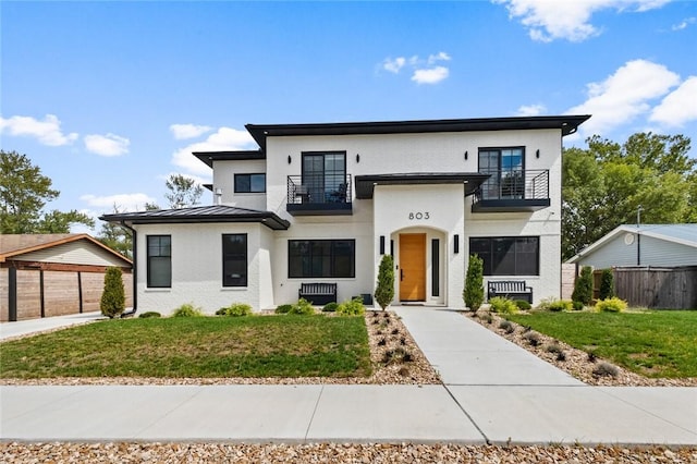 view of front of home featuring a balcony and a front lawn