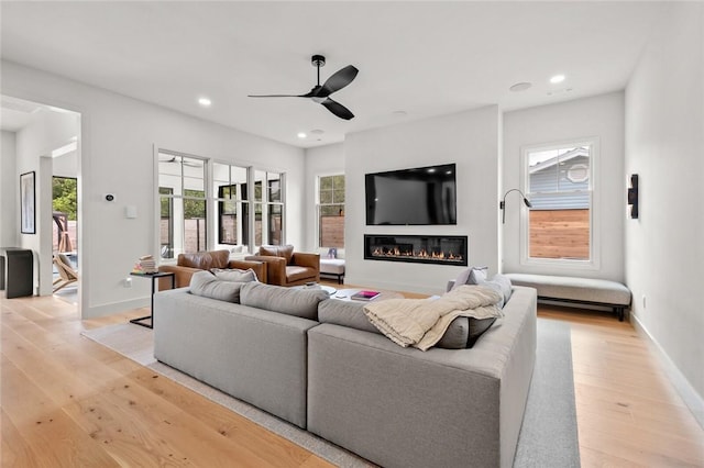 living room featuring ceiling fan and light hardwood / wood-style floors