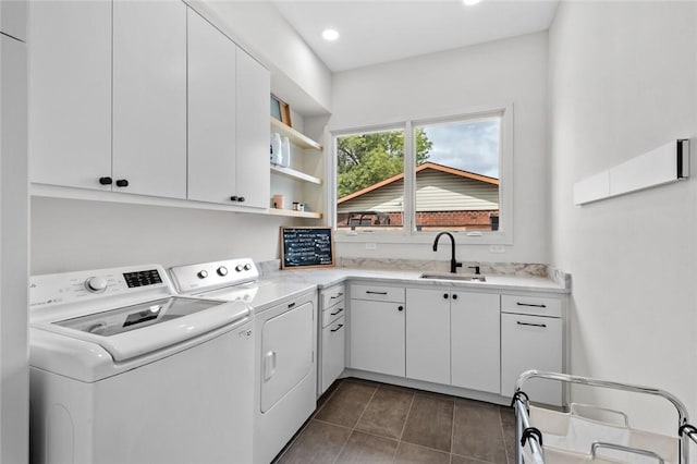 washroom featuring sink, washer and clothes dryer, cabinets, and dark tile patterned floors