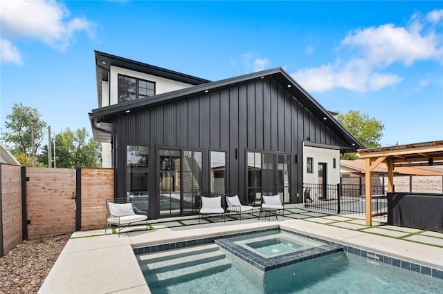 rear view of property featuring a swimming pool with hot tub and a patio area