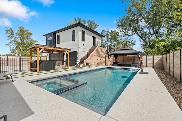 rear view of house with a gazebo, a swimming pool with hot tub, and a patio