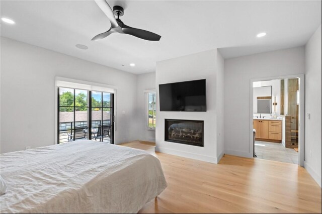 bedroom featuring light hardwood / wood-style flooring, ensuite bathroom, ceiling fan, and access to outside