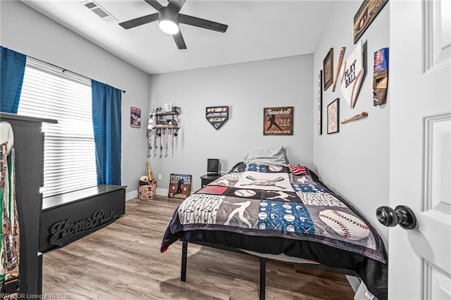 bedroom with visible vents, ceiling fan, baseboards, and wood finished floors