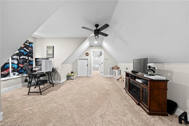 interior space featuring a ceiling fan, baseboards, vaulted ceiling, and carpet flooring