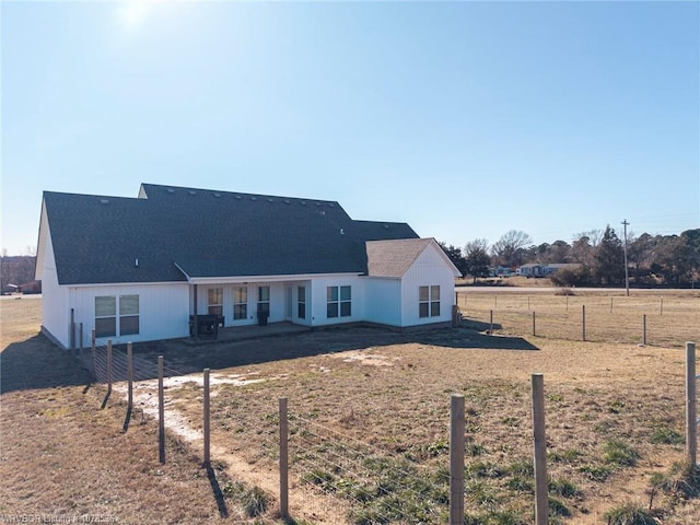 view of front of home with a rural view and fence