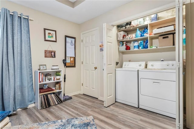 washroom featuring laundry area, independent washer and dryer, light wood-style flooring, and baseboards