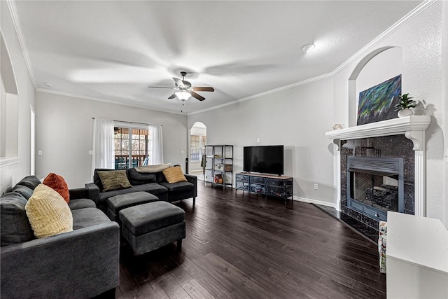 living room featuring dark hardwood / wood-style flooring, crown molding, a high end fireplace, and ceiling fan